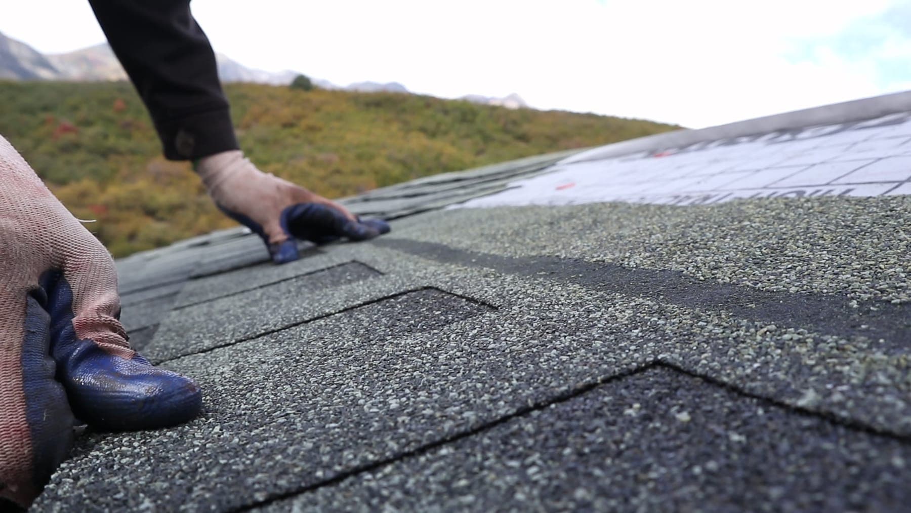Legacy Roofing installer fastening ridge cap shingles during a Utah roof repair