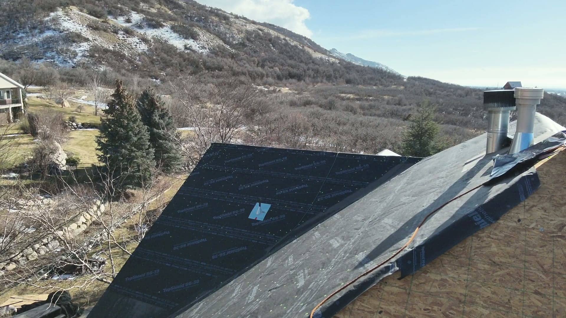 Aerial view of a Utah bench neighborhood with a roof dried in for shingles